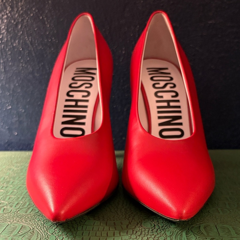 Moschino Tina tomato leather pumps w/ pointed toe, choked upper, and 110mm heel